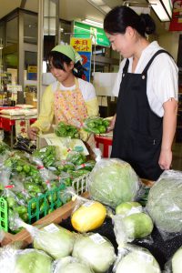 産直コーナーでの買い物を楽しむ親子