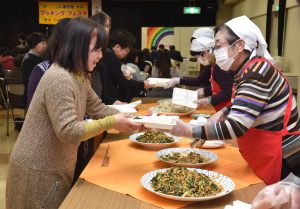 料理を盛り付ける女性部役員と参加者
