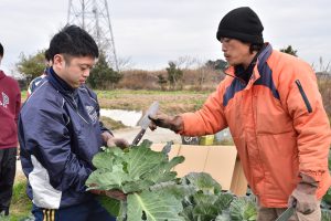 内定者に収穫作業を指導する山口さん(右)