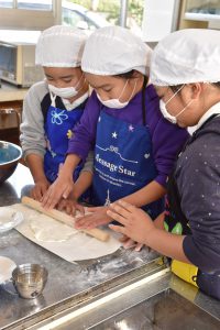 うどんの生地を麺棒で伸ばす(西野町小)