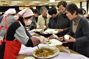 料理を盛り付ける女性部役員と参加者ら
