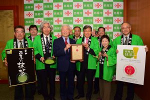 『西尾の抹茶』の登録証を持つ杉田芳男代表理事(前列右から3人目)と榊原康正西尾市長(前列右から4人目)、西尾茶協同組合の関係者ら