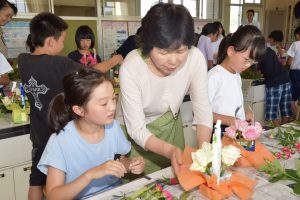 児童にアレンジフラワーを指導する生産者