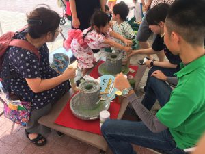 抹茶の石臼挽きを体験する参加者