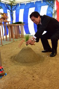 起工式で刈初の儀を行うJAの名倉組合長