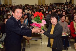 閉校式でＪＡの名倉組合長（左）から鉢花を贈られる代表者の広瀬さん（右）