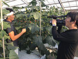 農作業風景の取材を受ける秋山さん（左）