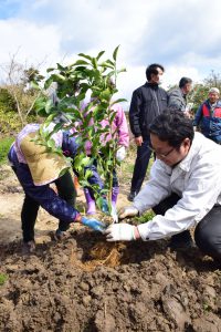 県職員（右）とともにレモンの苗木を実際に植える島民